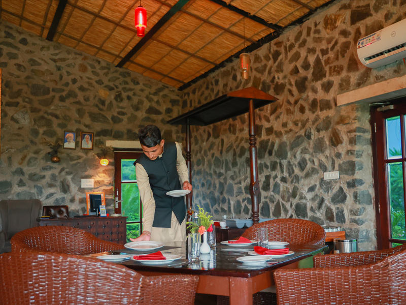 A welcoming dining room with stone walls and a table being prepared