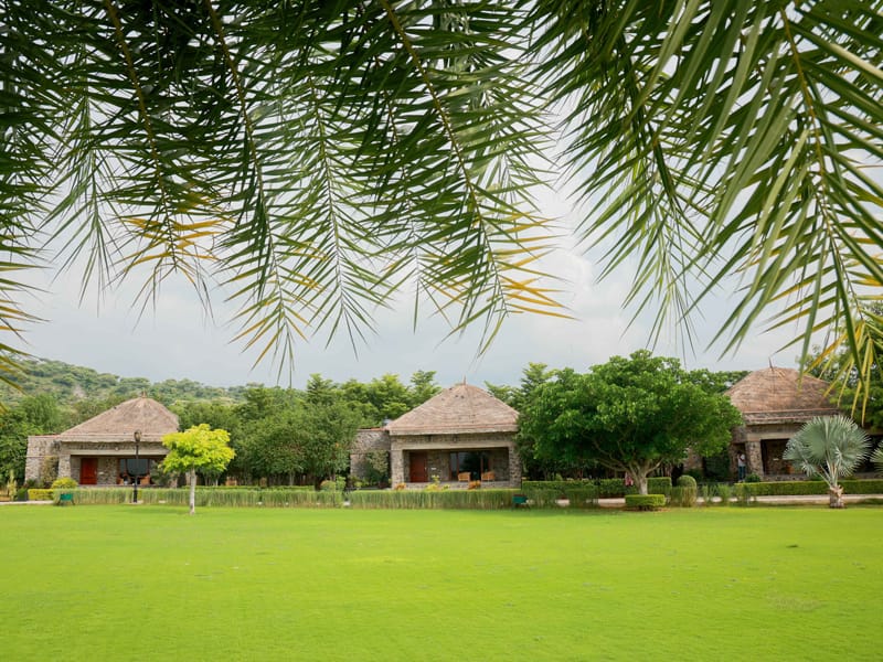 Stone cottages and green lawns at Sinny’s Luxury Lake Resort